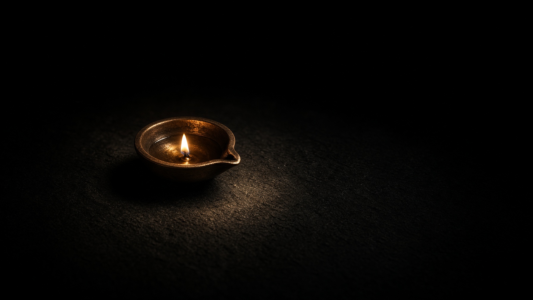 A small bronze lamp as the only light in darkness.