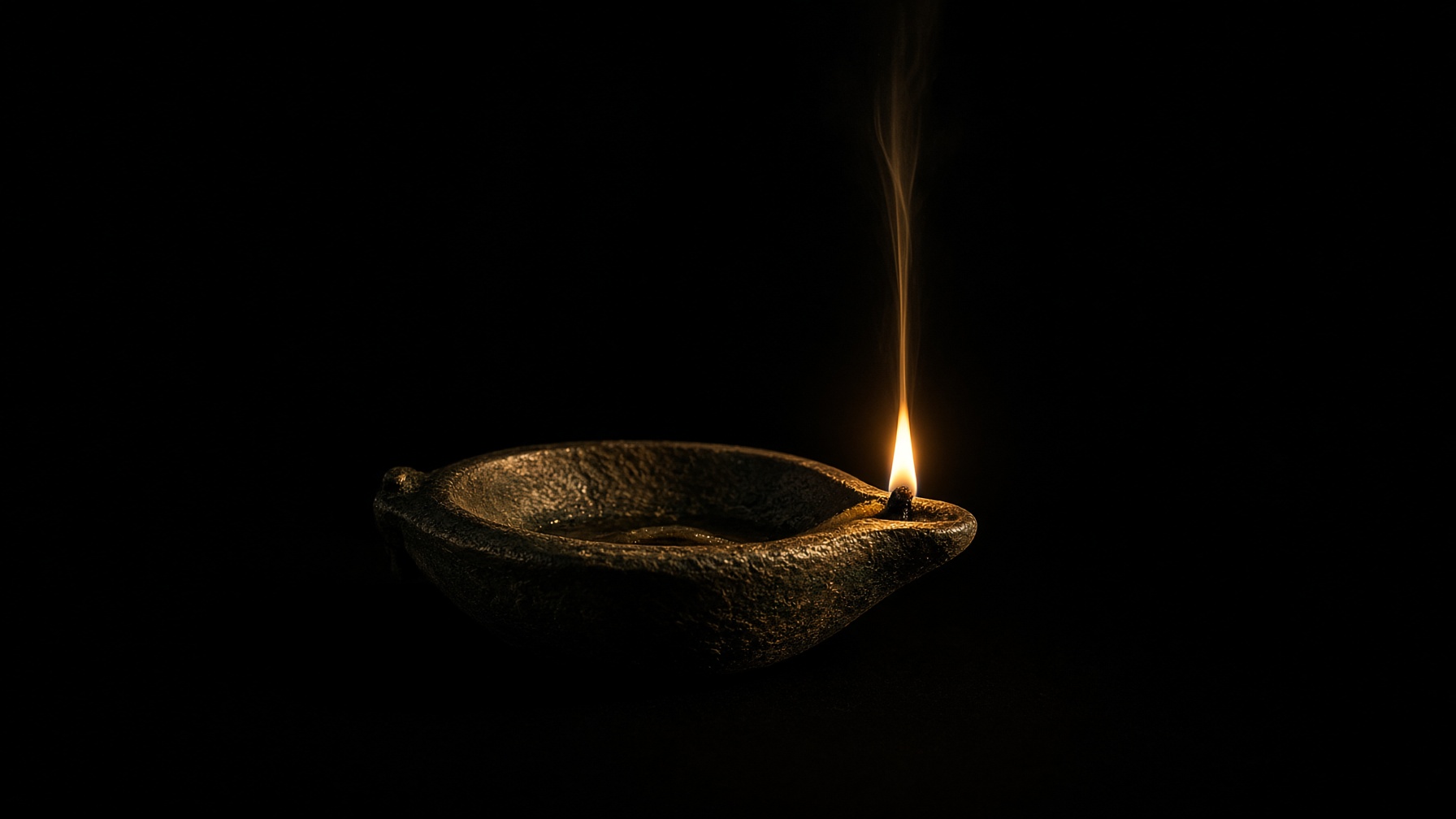 A bronze lamp reduced to one gold filament of flame in darkness. No body. No portrait.